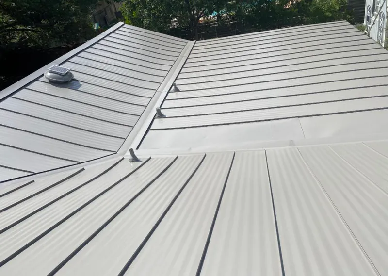 Solar attic fan installed on a metal roof for Roof Ventilation in Metropolis